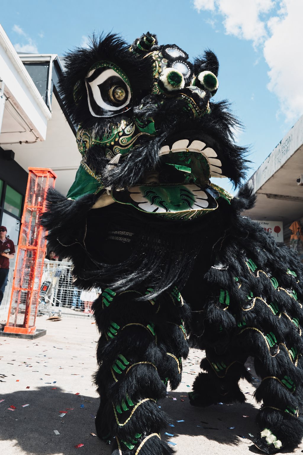 Chao Yi lion dance performer in black, green and gold costume